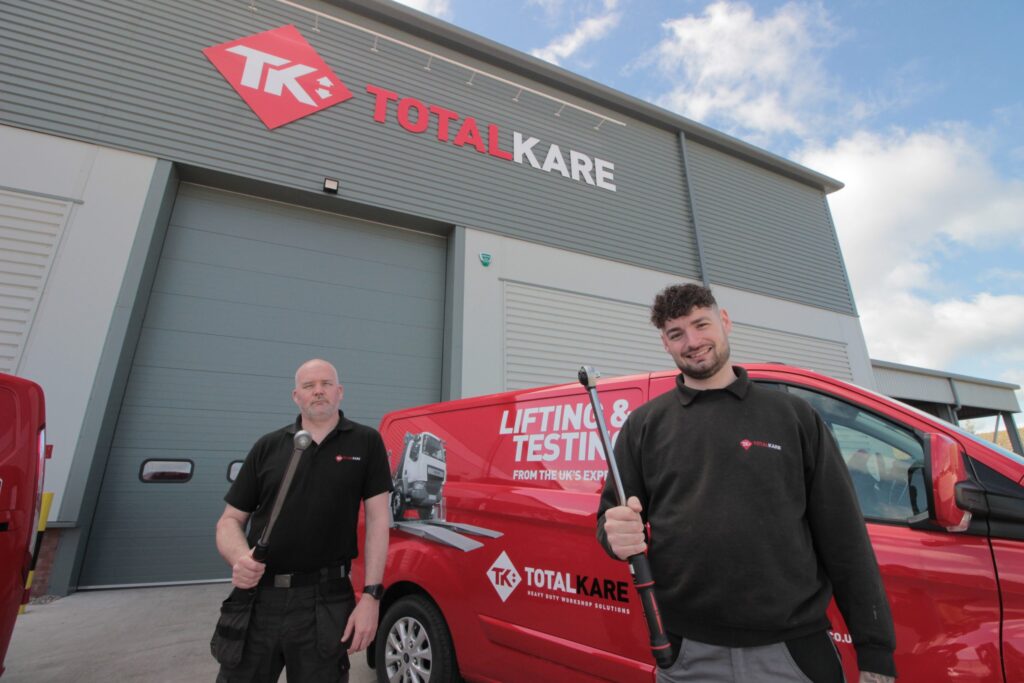 Totalkare staff holding torque tools outside their warehouse