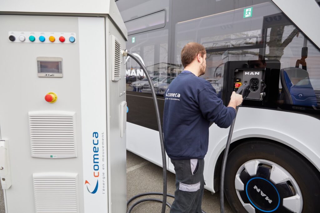 A comeca employee plugging an electric bus into the Amber 2 charging point
