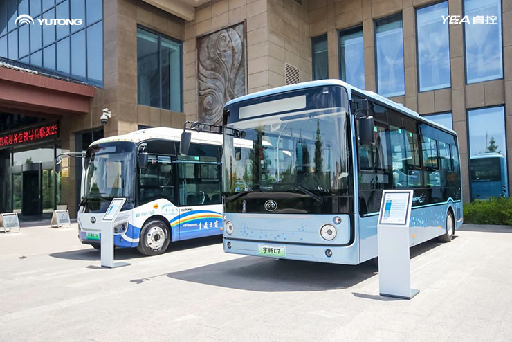 2 Yutong electric buses parked outside a hotel