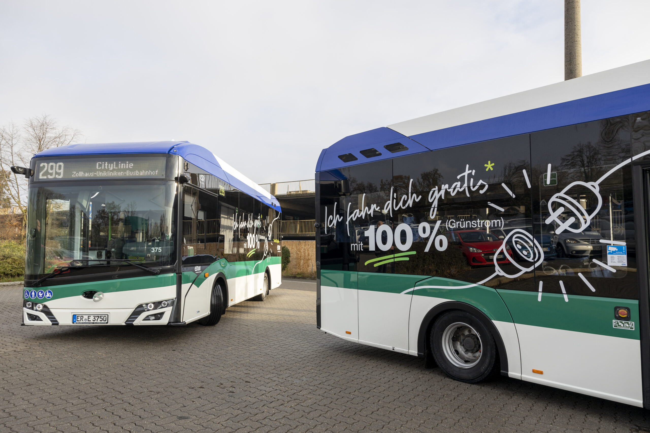 Two buses alongside each other, one daubed in german writing
