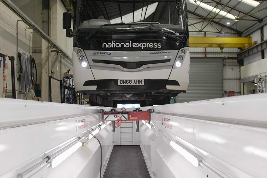 A National Express coach lifted into the air above a maintenance pit