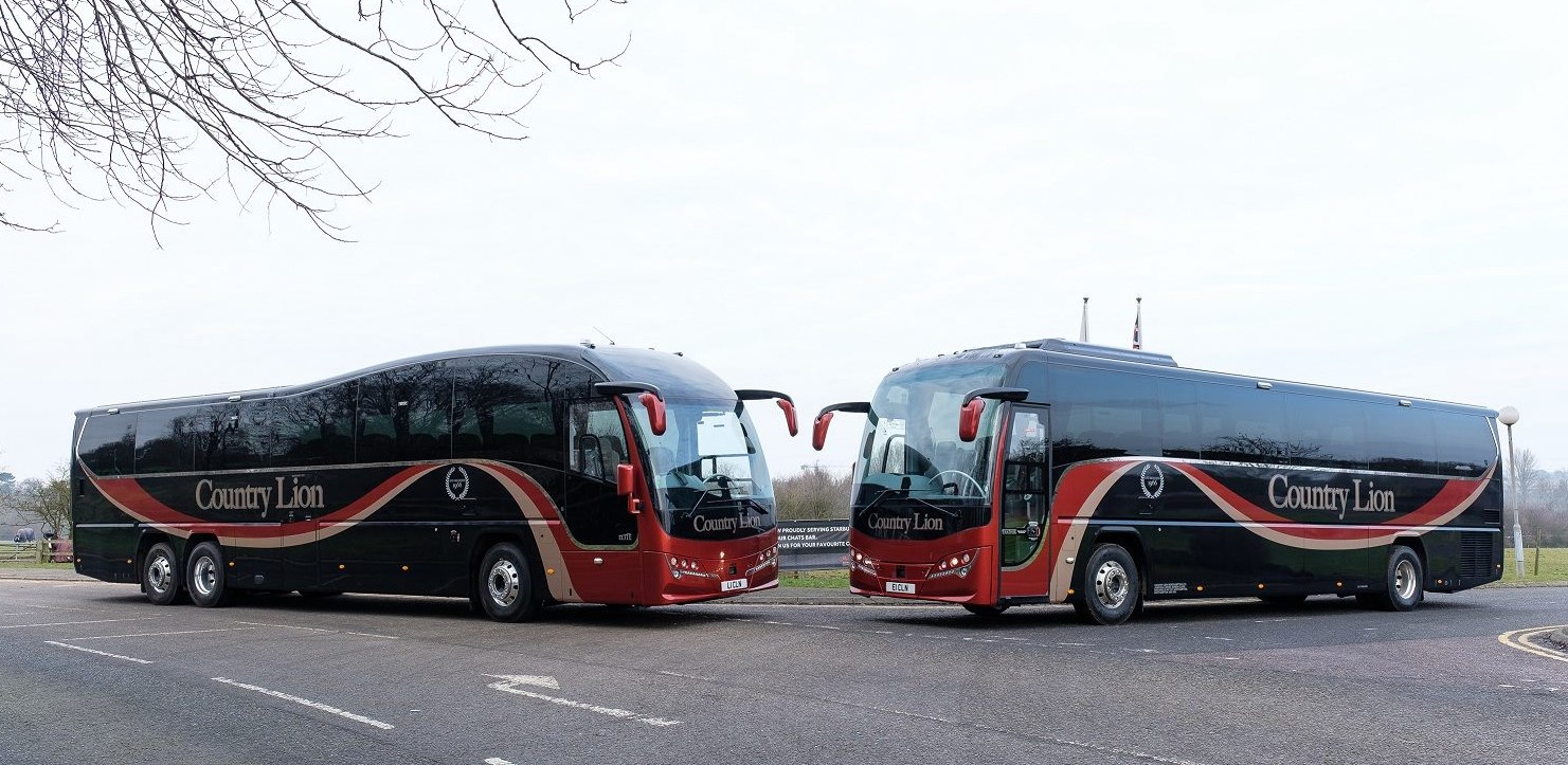two country lion buses standing opposite to each other in color red and navy blue