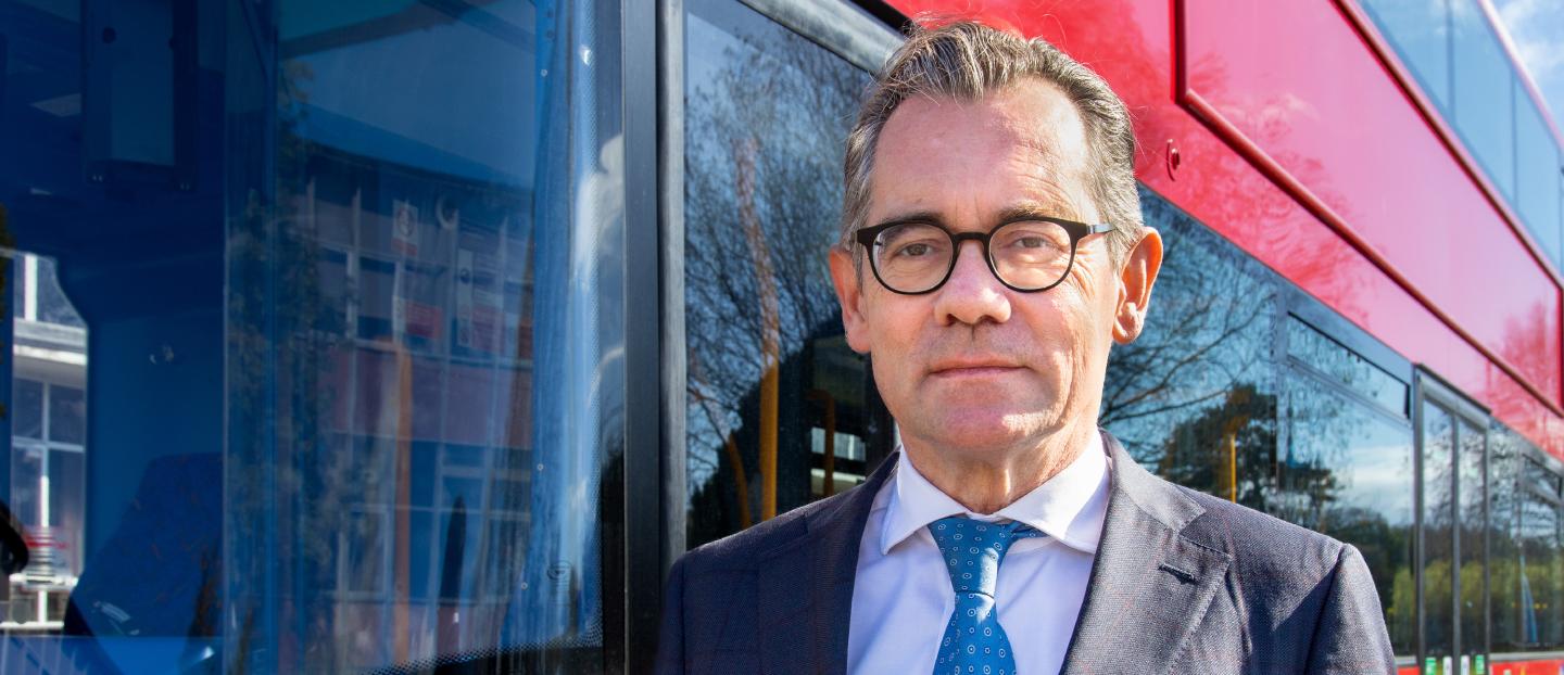 An image of Wrightbus CEO Jean-Marc Gales stood in front of a bus