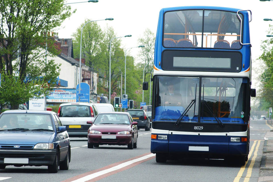 A bus alongside cars on a road in England