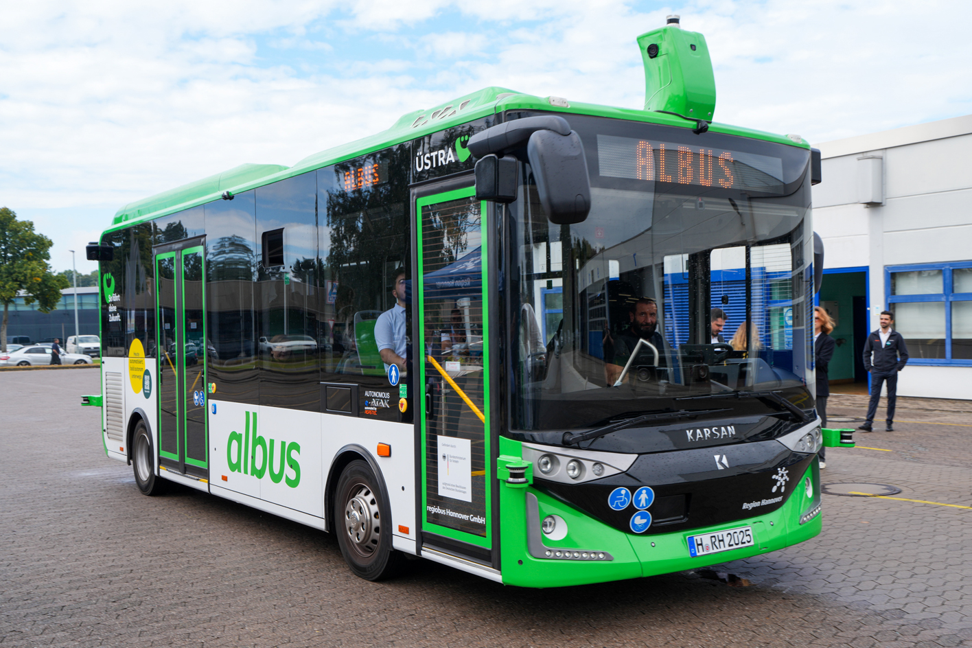 A predominately green Karsan autonomous vehicle