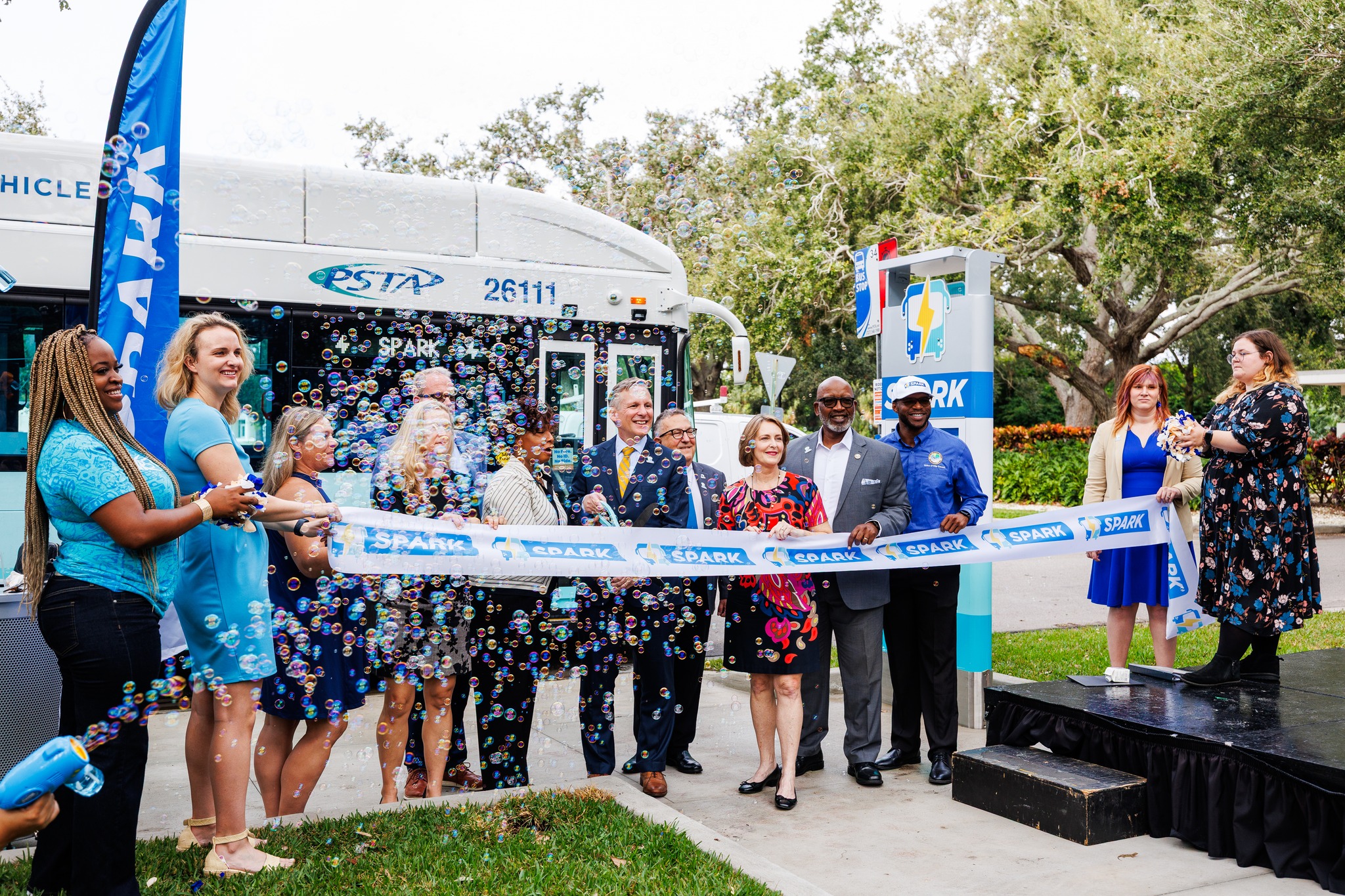 A group celebrating the launch of a bus service