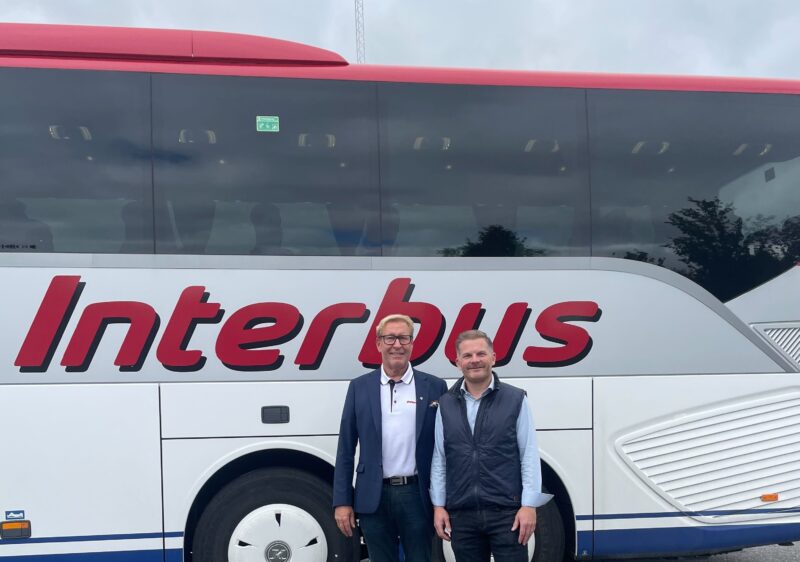 Two men in front of a bus