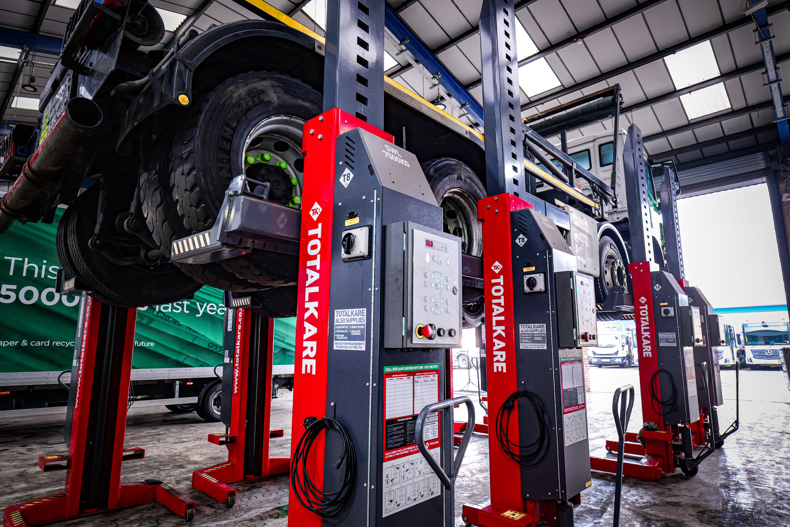 A Totalkare mobile column lift raising a truck bed off the ground in a workshop