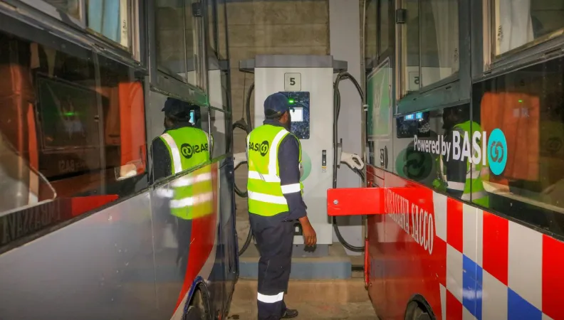 Two people in high-visibility jackets performing vehicle maintenance
