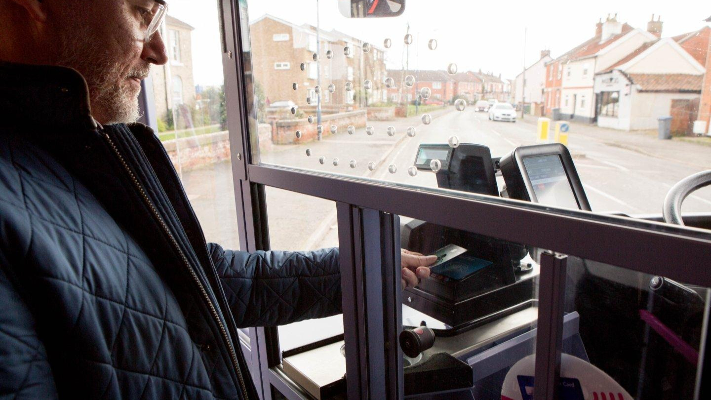 A man paying for his bus journey with a contactless card