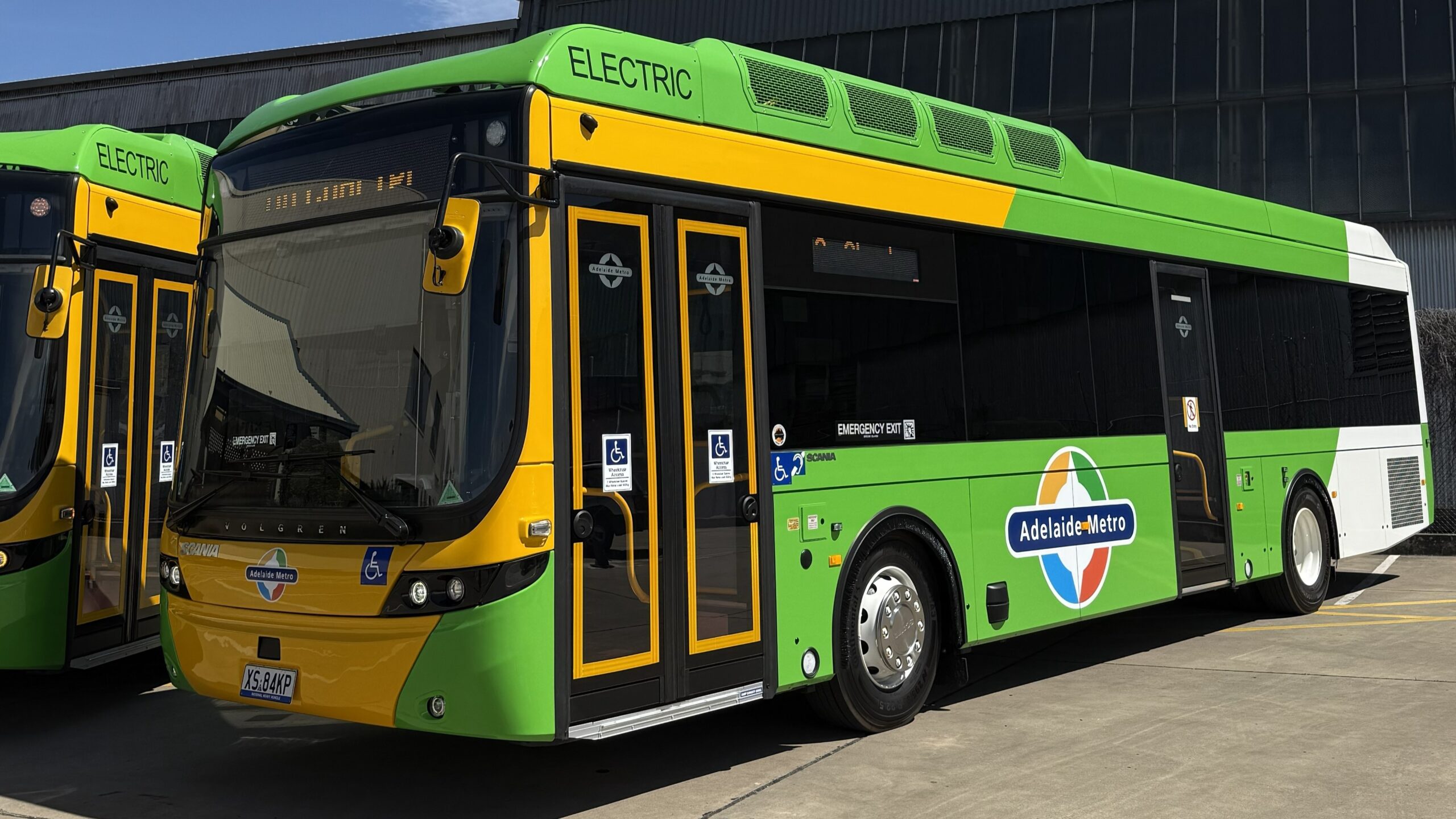 A green and yellow electric bus