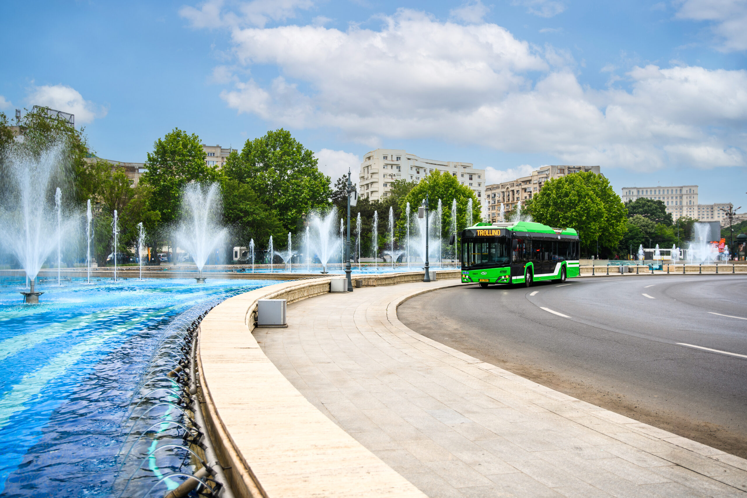 A bus by a large fountain