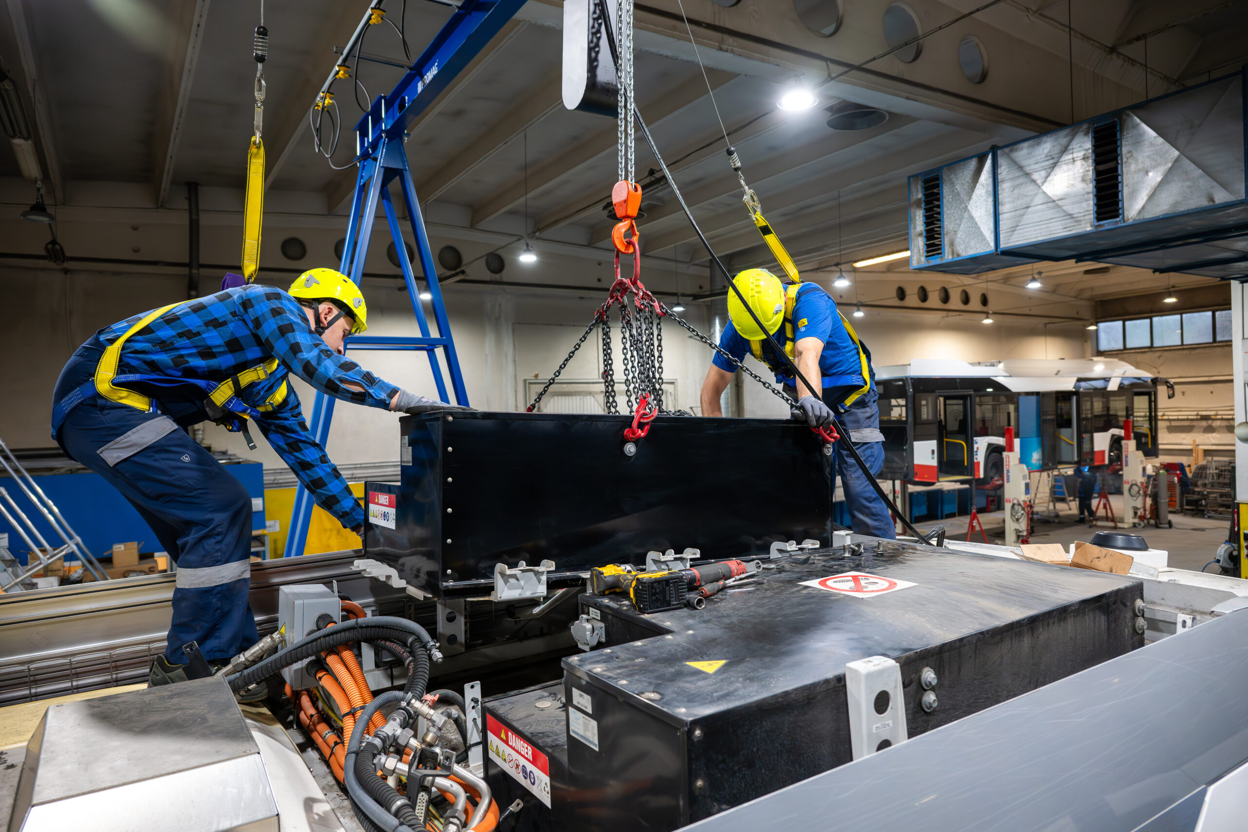 Two workers retrofitting a bus