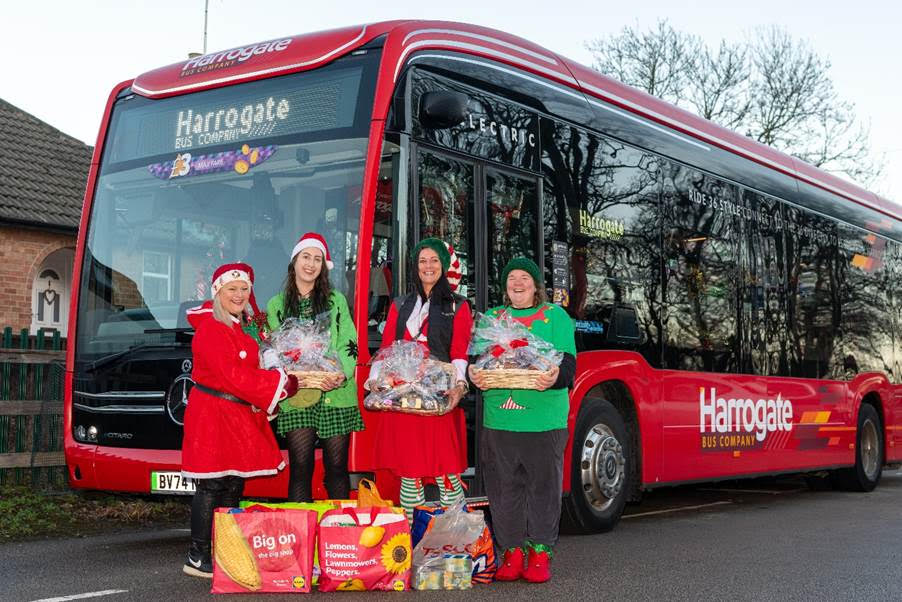 People stood by a large red bus with presents and food