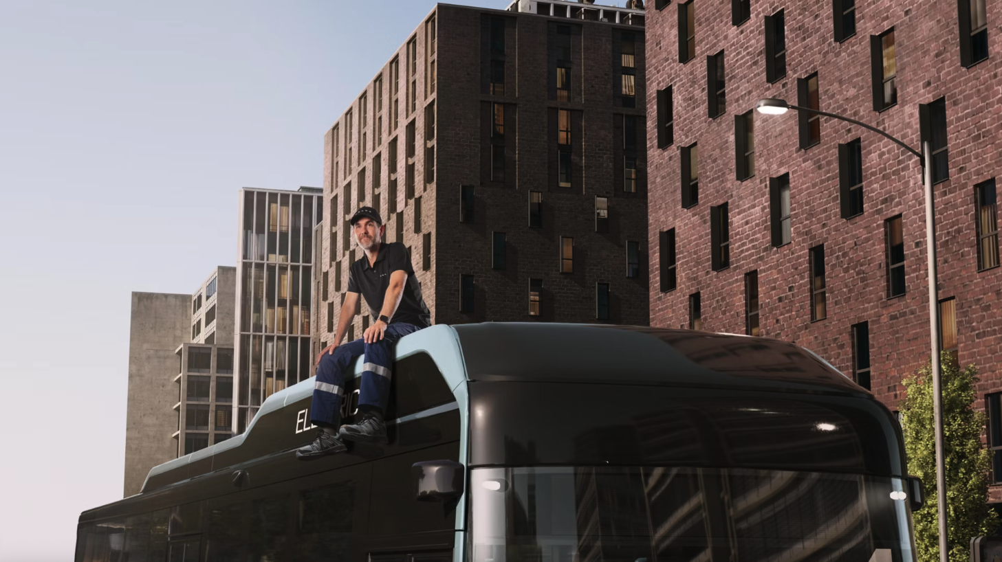 A man sat on top of a bus