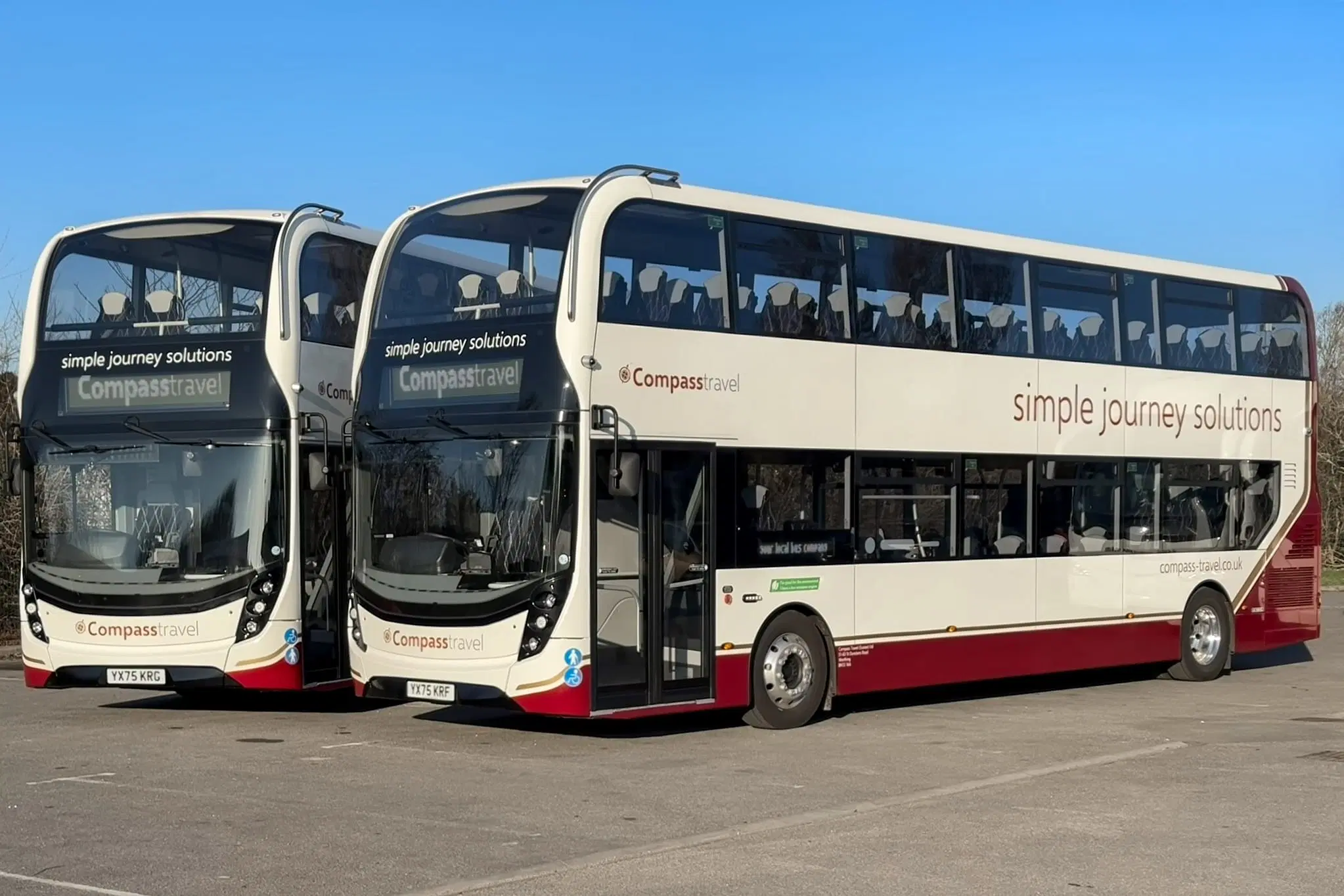 Two maroon and white Alexander Dennis buses