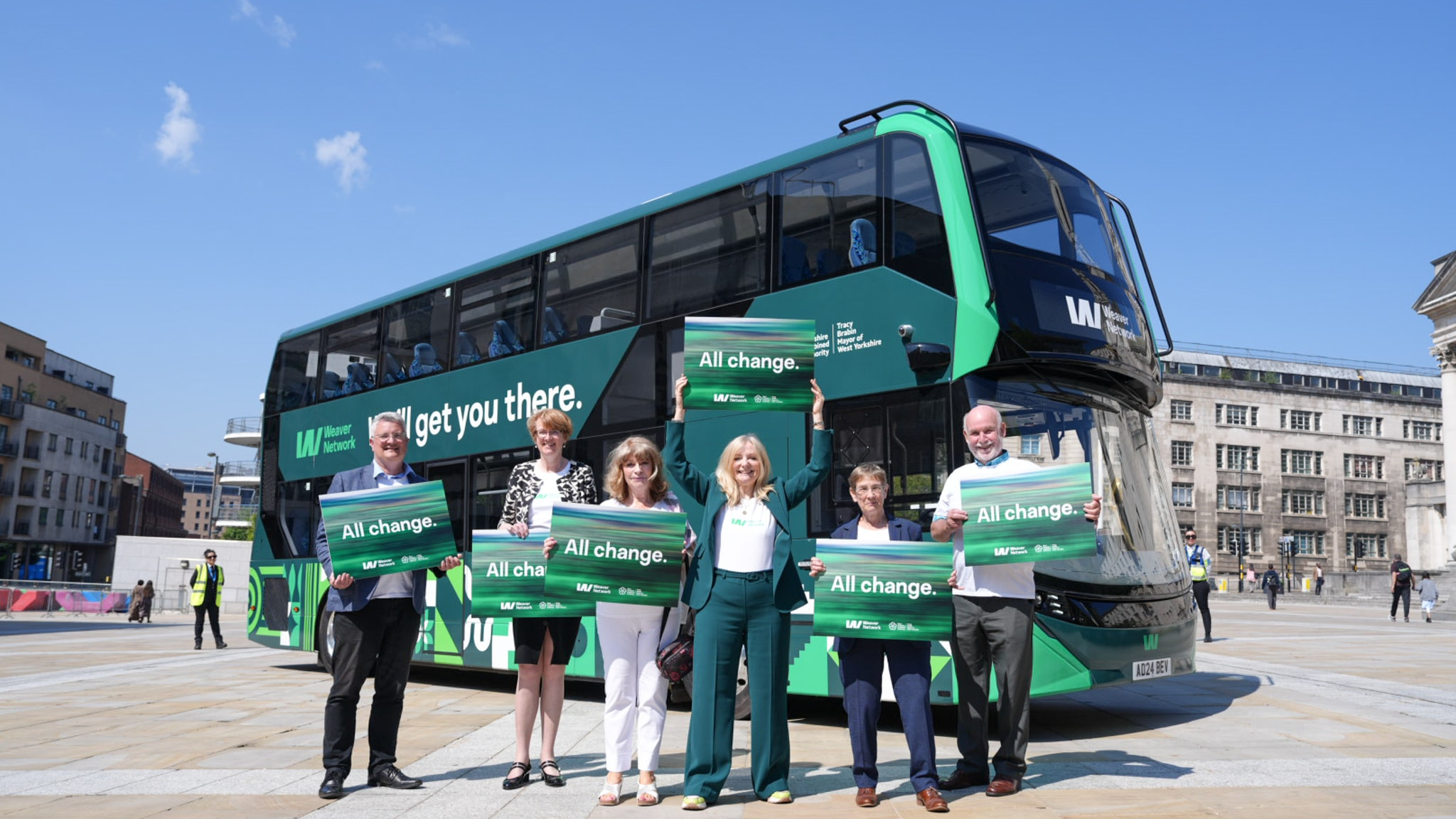 People stood by a green bus