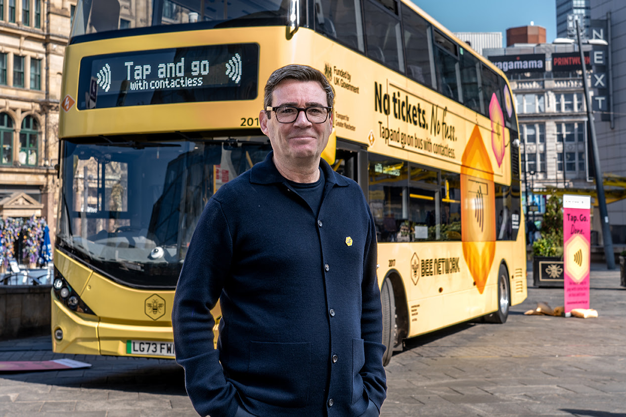Andy Burnham stood in front of a bus