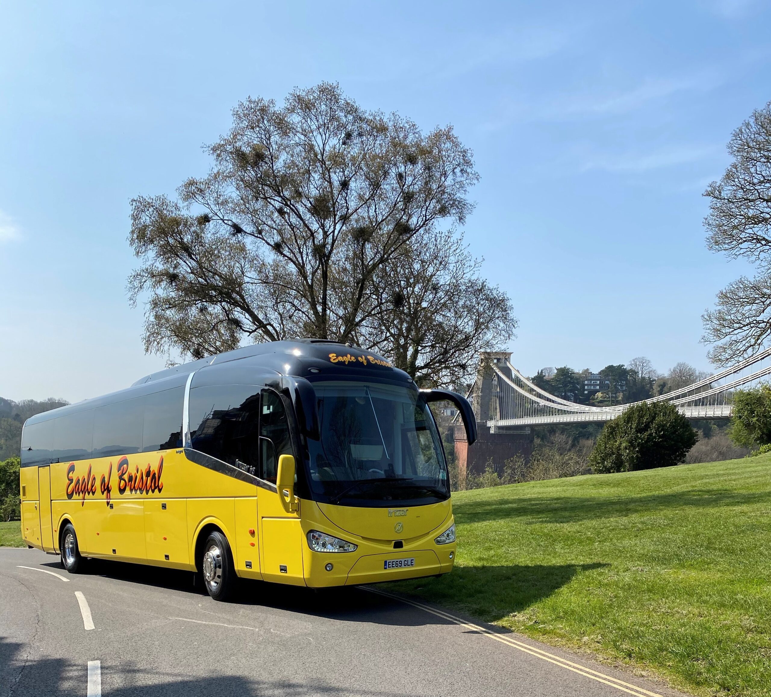 A yellow coach by a roadside