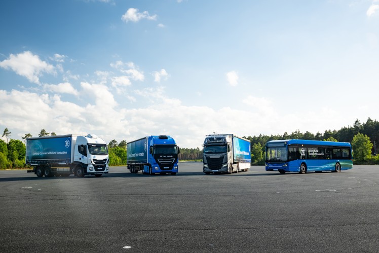 Line up of different vechicles, like trucks and buses