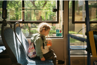 Child on bus drinking a drink through a straw