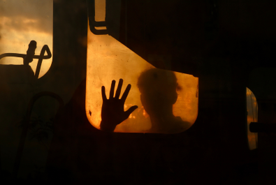 Vehicle window with shadowy figure looking through