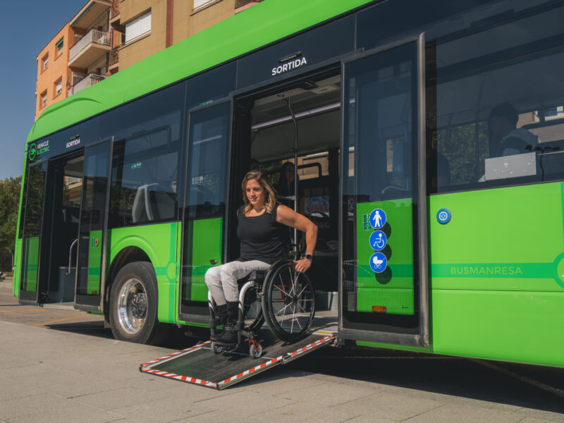 a wheelchair user getting off a bus using a ramp