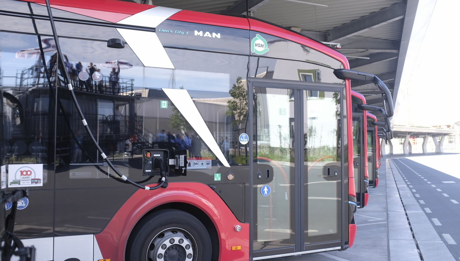 A row of MAN Lion's City E electric buses charging at a depot