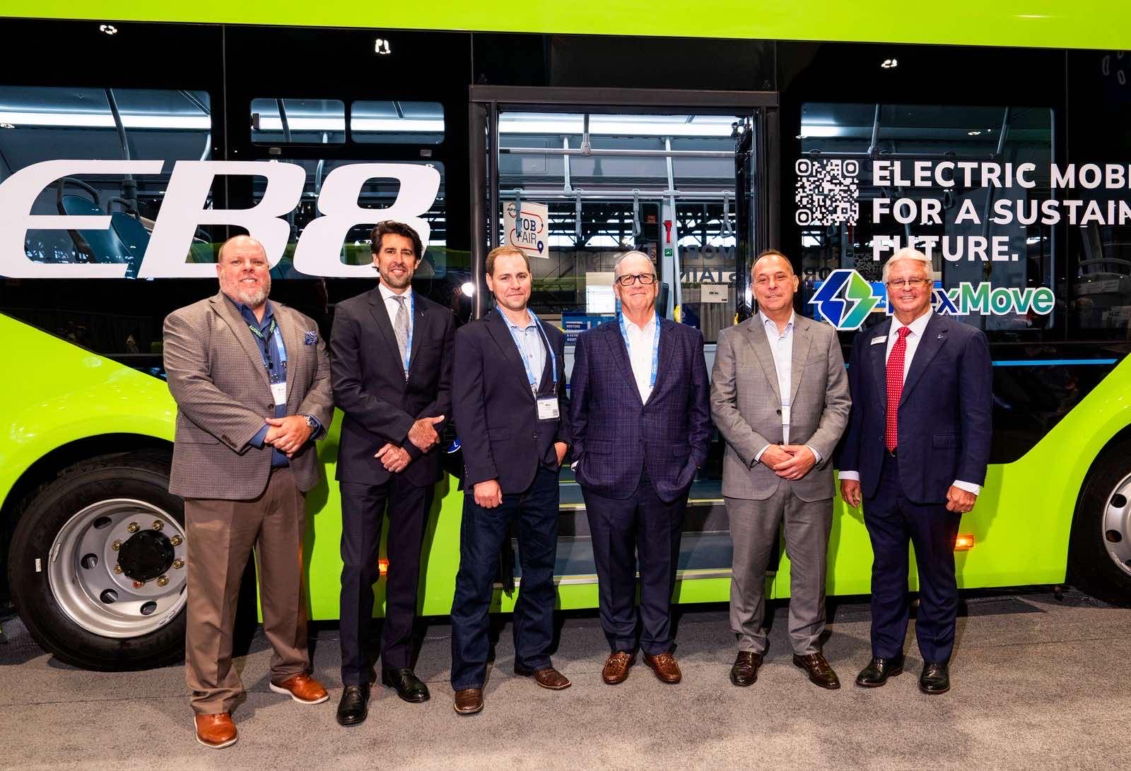 VinFast and NexMove representatives stood in front of a green VinFast bus